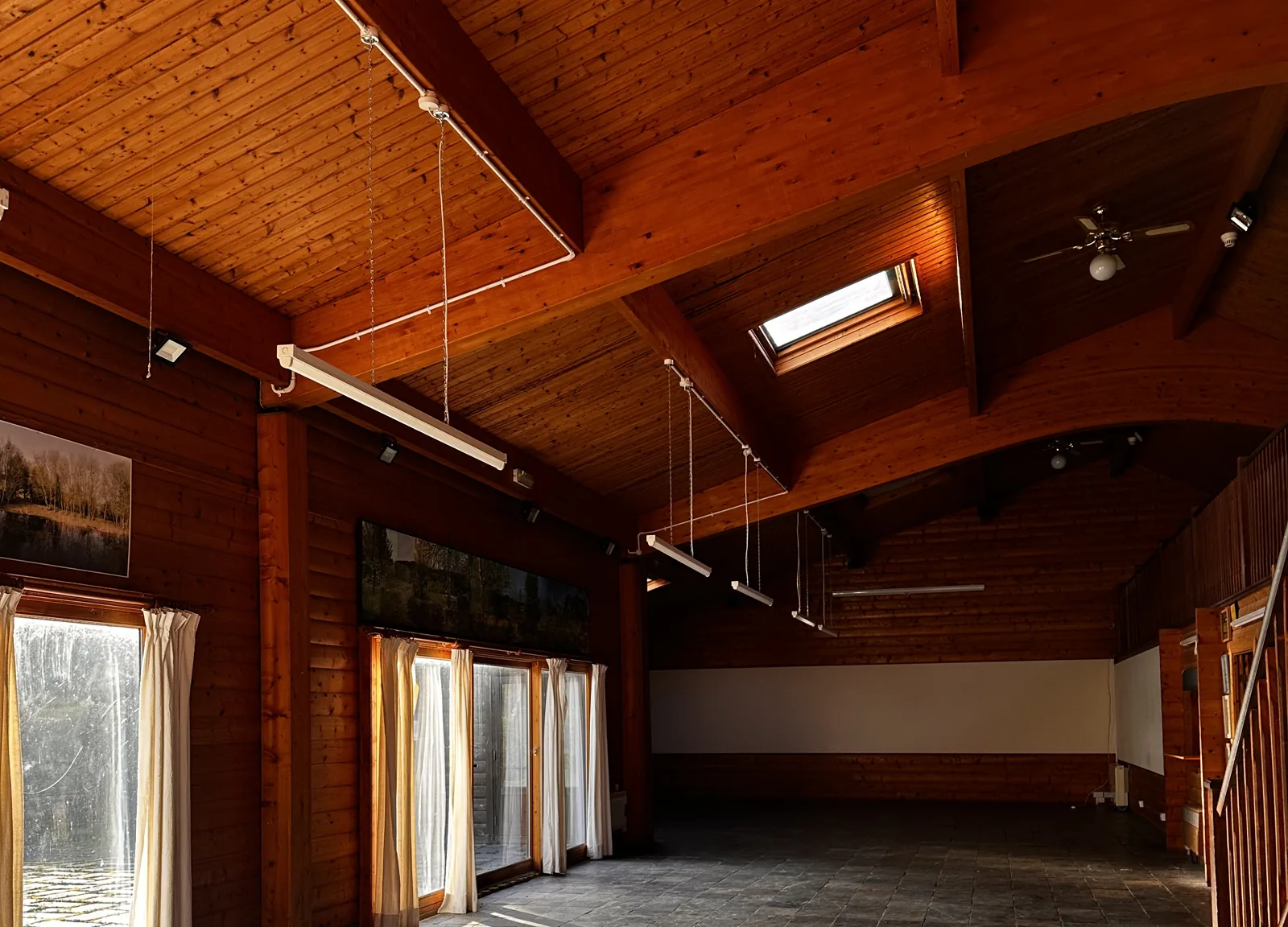 Glazed doors and curtains in the Fairmont hall, with sunlight on the slate floor