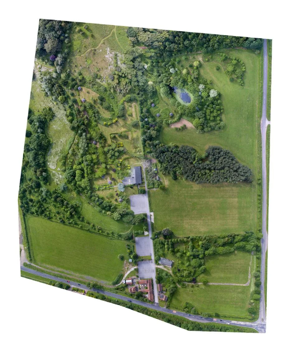 Aerial photograph of the whole estate showing buildings, car parks, woodland, a pond and open fields
