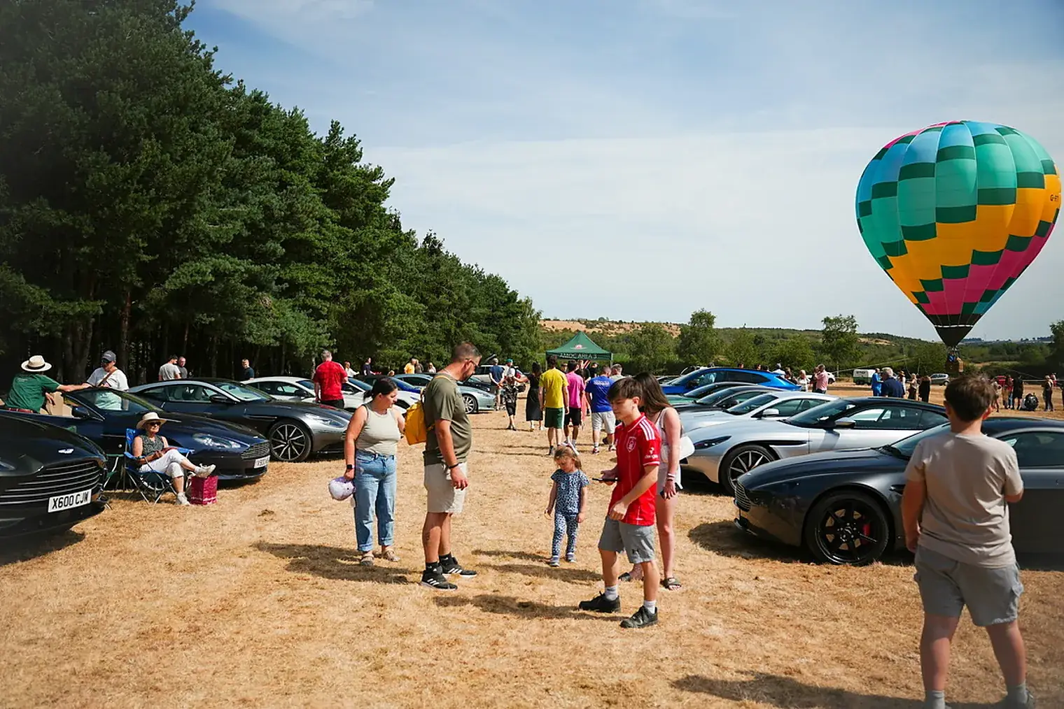 Visitors and cars beneath a hot-air balloon at an Overdrive show