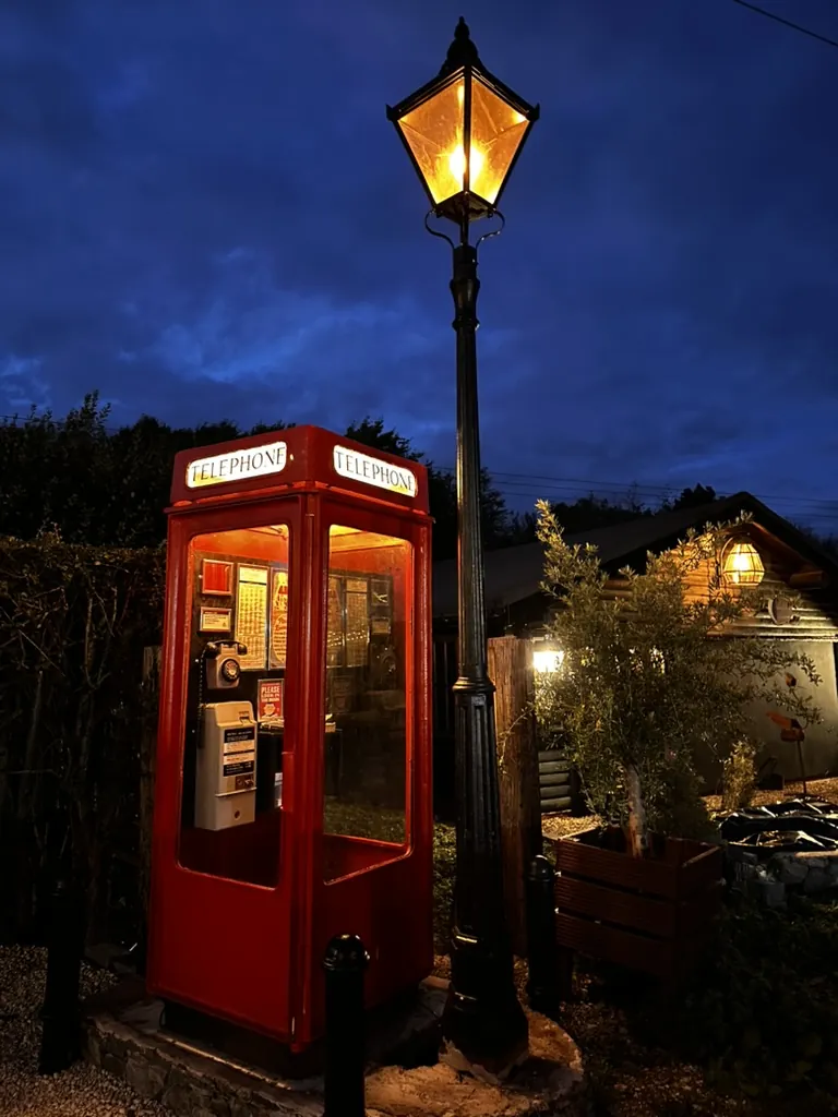 Red telephone box lit at night at Christmas