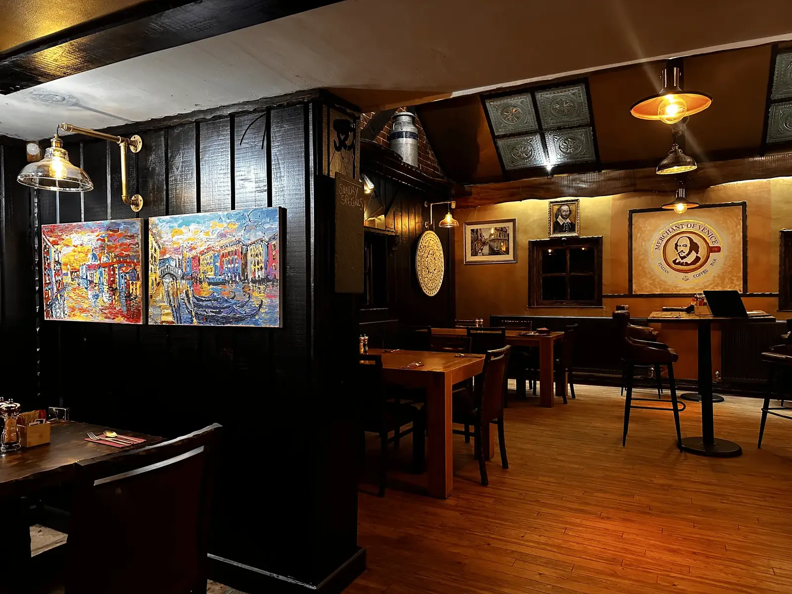 Merchant of Venice dining room with timber panelling, lamps and colourful paintings