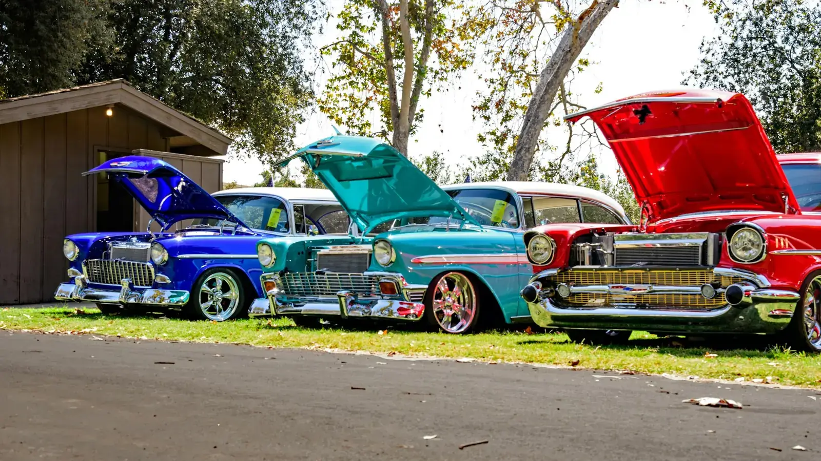 Classic cars with bonnets open at a car show